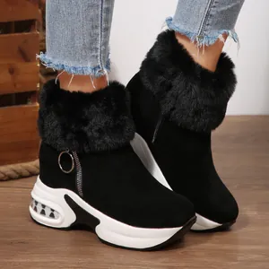 Close-up of black women's platform snow boots with faux fur trim and side zipper