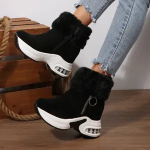 Detailed shot of women's black platform snow boots featuring faux fur and side zipper.