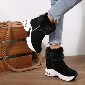 Close-up of women's black platform snow boots featuring faux fur trim and a side zipper.