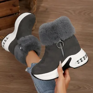 Close-up detail of grey faux fur lining and circular zipper pull on women platform snow boots