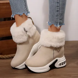 Close-up of stylish beige wedge snow boots with plush fur collar and side zipper
