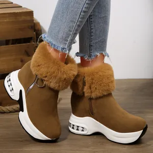 Detail view of brown platform snow boots with plush fur trim and side ring zipper