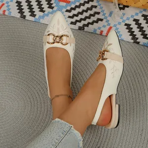 Detail shot of embroidered pointed-toe slingback flats with decorative gold chain buckle