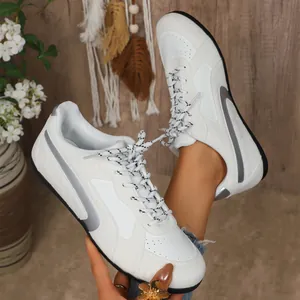 Vue détaillée des baskets blanches pour femmes de style GAT avec accents argentés et lacets