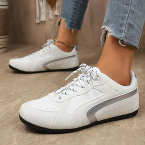 Gros plan de baskets blanches pour femmes avec rayures argentées et semelle en caoutchouc
