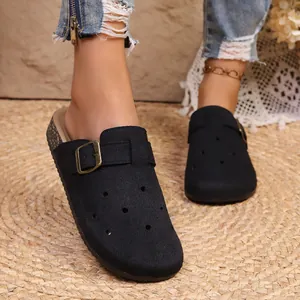 Detailed view of black retro platform clogs featuring buckle strap and breathable holes
