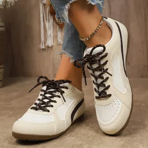 Gros plan de baskets bicolores pour femmes avec lacets marron et semelles gomme