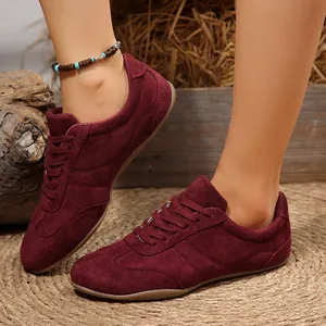 Κοντινό πλάνο σε μπορντό σουέτ sneakers με μαλακή υφή και επίπεδη σόλα σχεδιασμό