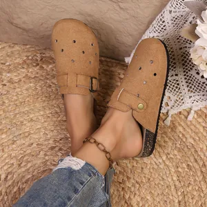 Close-up of retro camel suede Boston clogs with buckle strap and cork sole detail