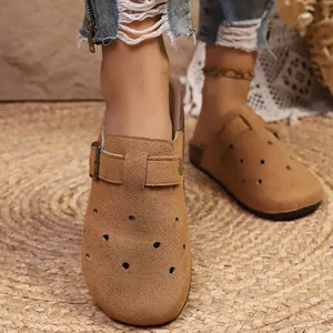 Close-up detail of retro brown suede closed-toe clogs with adjustable metal buckle strap