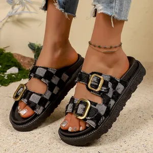 Close-up of stylish checkerboard platform sandals with gold buckles and thick soles