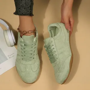 Λεπτομερής προβολή γυναικείων σουέντ sneakers σε ανοιχτό πράσινο χρώμα με κορδόνια