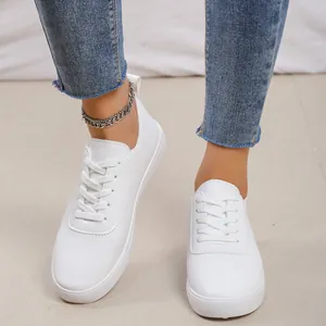 Λεπτομέρεια από λευκά γυναικεία sneakers με μοντέρνο βραχιόλι αστραγάλου και τζιν