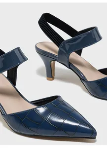 Λεπτομέρεια από σκούρο μπλε γόβες slingback με ελαστικό λουράκι και κροκό σχέδιο.