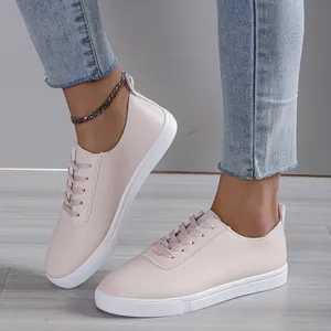 Λεπτομερής προβολή των ροζ sneakers με κορδόνια και επίπεδη λευκή σόλα καουτσούκ