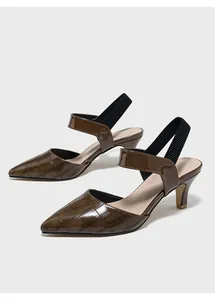 Λεπτομέρεια από καφέ λουστρίνι γόβες slingback με κροκό σχέδιο και μαύρο λάστιχο.