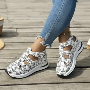Detailed shot of white floral platform sandals on a wooden deck