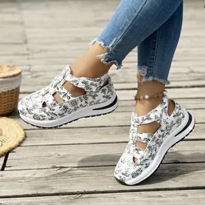 Close-up of white floral pattern sandals with thick platform soles and velcro straps.