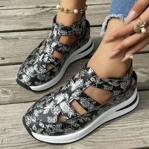 Close-up of floral print wedge sandals with thick platform soles on a wooden deck.