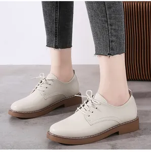 Close-up of women's beige leather Oxford shoes with lace-up design and gum sole