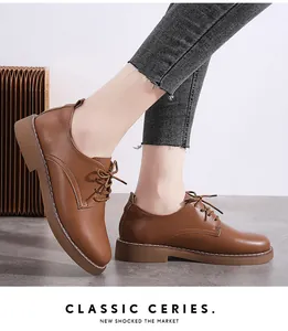 Detail view of brown lace-up leather Oxford shoes for women with stylish white stitching