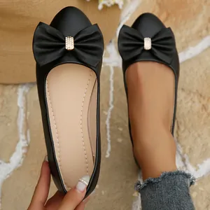 Detailed view of elegant black pointed toe ballet flats featuring a stylish bow and rhinestones