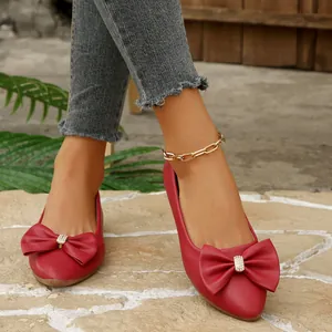 Elegant red pointed toe ballet flats featuring a large bow with rhinestone center.