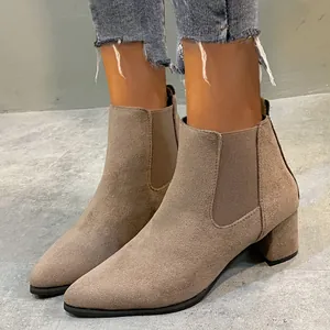 Close-up view of a model wearing stylish khaki suede Chelsea boots with a stable block heel