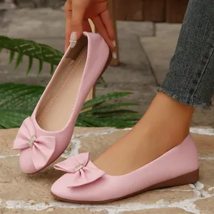 Elegant pink ballet flats featuring a rhinestone bow and pointed toe design for women.