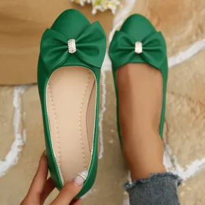 Vibrant green pointed-toe ballet flats with elegant bowknot and sparkling rhinestone detail.