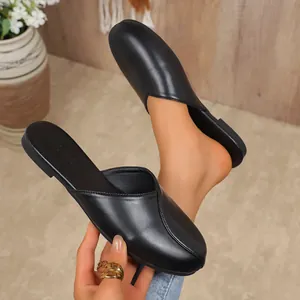Close-up view of elegant black closed-toe flat mules for women with soft faux leather finish