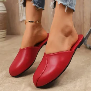 Detailed view of red closed-toe flat mules with round toe and soft leather finish