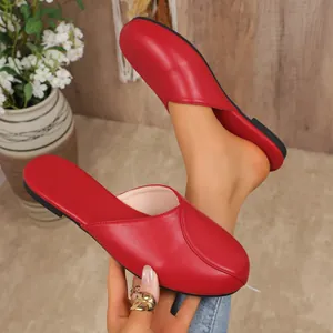 Detail shot of red closed-toe flat mules for women with soft faux leather texture
