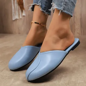 Close-up of light blue flat closed-toe mule slippers with soft leather texture