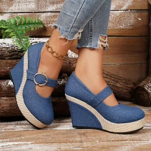Close-up detail of blue denim wedge Mary Janes with woven platform and buckle strap design