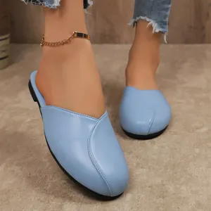 Detailed view of women's light blue flat closed-toe mule slippers with round toe design