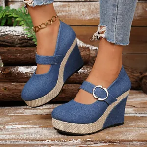 Close-up of denim wedge shoes featuring straw-braided platform and silver buckle
