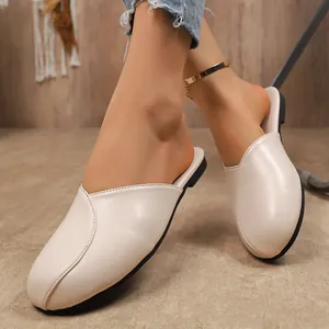 Detailed view of comfortable beige flat closed-toe mules for women in summer style.