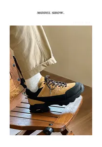 Close-up of tan and black men's outdoor hiking shoes on a wooden chair detail.
