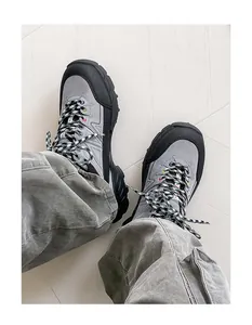 Top-down view of grey hiking shoes with checkered laces on white wooden floor