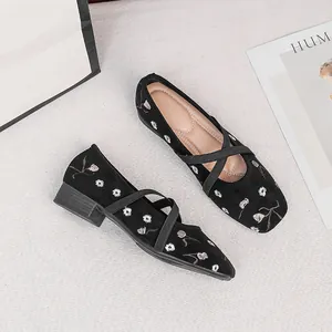 Detailansicht der schwarzen Mary Jane Schuhe mit Blumenstickerei und gekreuzten Riemen