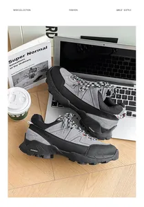 Detail view of grey hiking sneakers on a laptop, showing rugged sole and checkered laces.