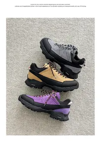 Detailed view of three colorful hiking shoes stacked on a textured grey surface