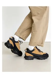 Detailed side view of khaki and black men's outdoor hiking shoes worn with pants