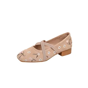 Detailansicht der beigefarbenen Mary Jane Schuhe mit Blumenstickerei und Kreuzgurten