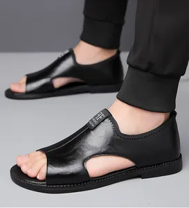 Detalle de sandalias de cuero negro con aberturas laterales y suela blanda flexible.