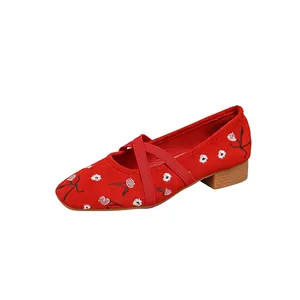 Detailansicht der roten Mary Jane Schuhe mit Blumenstickerei und eleganten Kreuzriemen