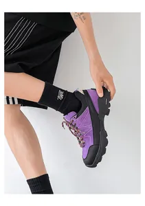 Close-up of a person wearing a purple and black hiking shoe with thick non-slip soles.