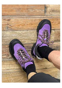 Top-down view of purple hiking shoes for men and women on a rustic wooden floor.