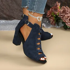 Detail von dunkelblauen Wildleder-Sandalen mit Blockabsatz, Schnalle und Kreuzriemen.